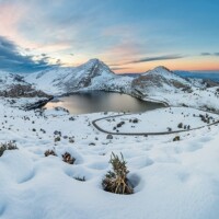 Covadonga lakes beautiful snowy winter landscape scene on a touristic location of Asturias, Spain, Europe, surrounded by mountains. Snow adventure leisure destination for holidays or vacations.